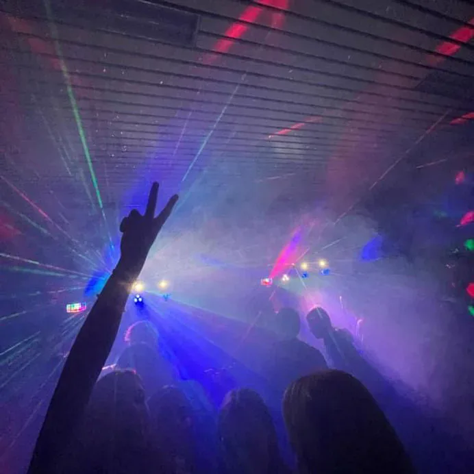 Licht en geluid huren in de Kempen — dansende feestgangers onder een lasershow met rook