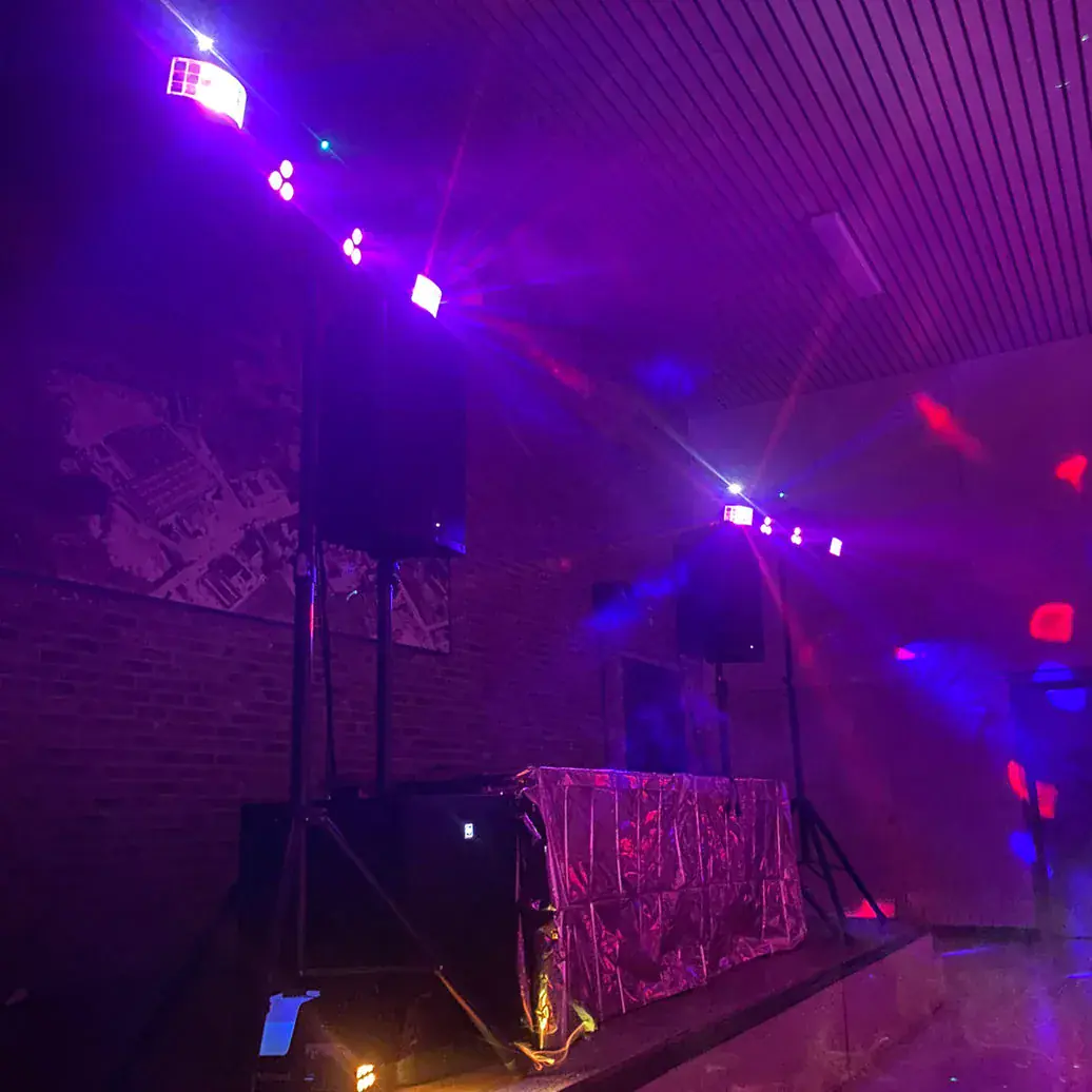 Sfeervolle zaalverlichting en gehuurde geluidsinstallatie tijdens een feest