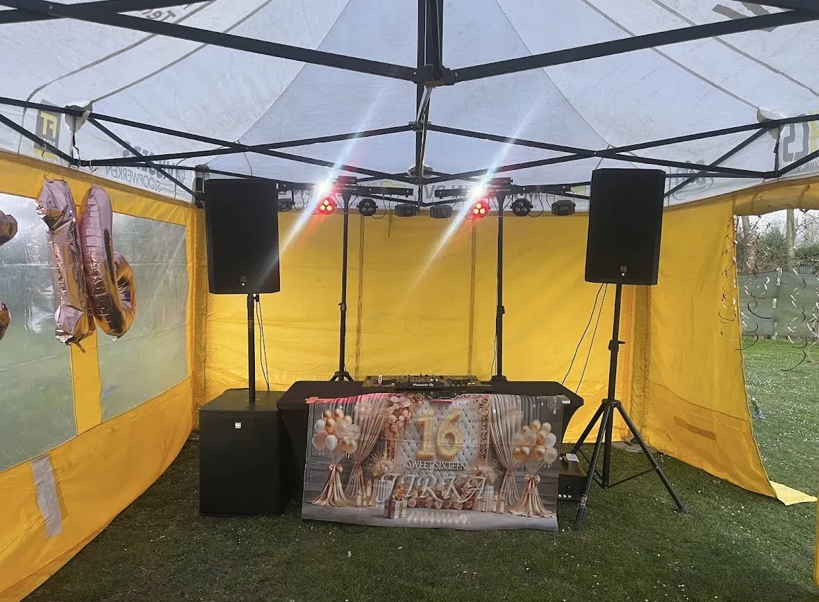 DJ-set onder gele partytent met Sweet 16 banner